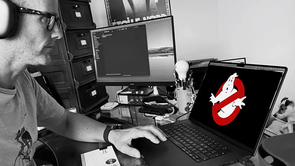 Olivier Van Meyel au travail sur un site client, deux écrans, casque sur les oreilles